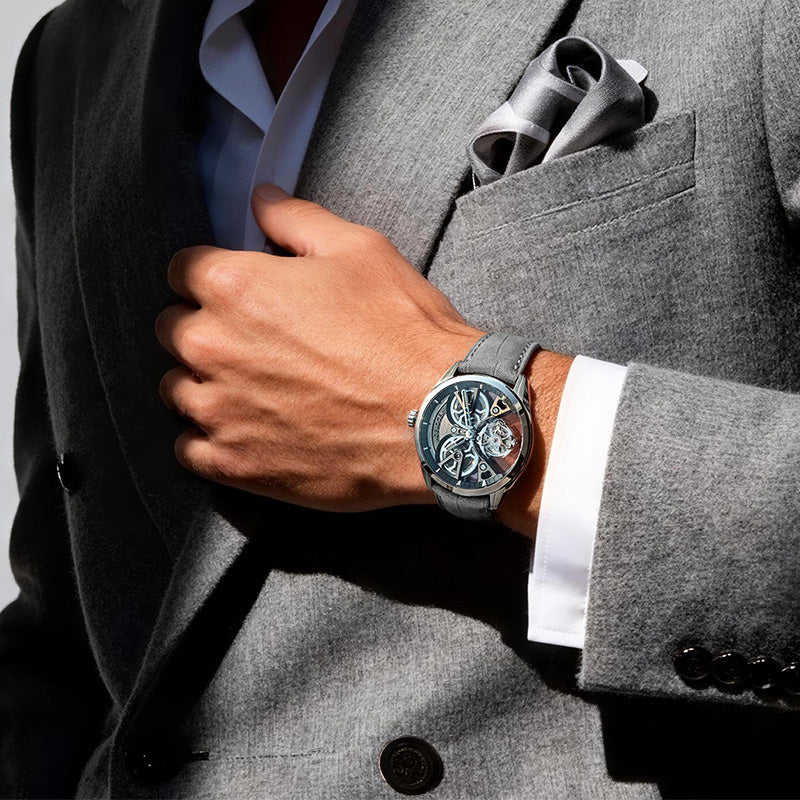 Agelocer 3D-Manta hand-wound flying tourbillon worn with a grey suit, cage visible at six o'clock