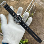 STEELDIVE SD1977T on a black rubber strap laid out full length on a gloved hand