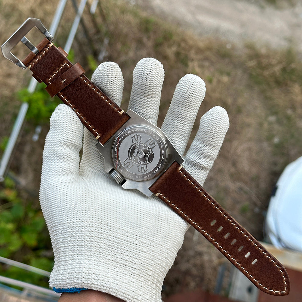 STEELDIVE SD2213 caseback view on its brown leather strap held in a gloved hand