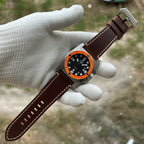 STEELDIVE SD2213 on a dark brown leather strap held across a gloved palm