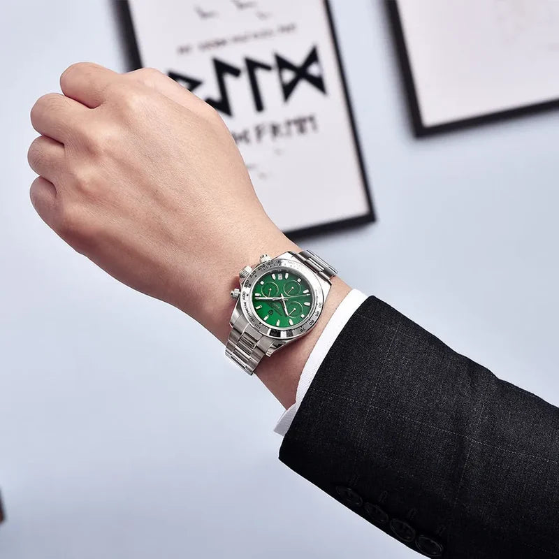 Hand wearing a silver watch with a green face on a light background