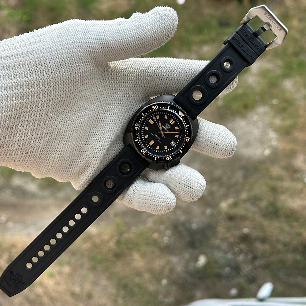 STEELDIVE SD1970X laid flat on a gloved hand with the full rubber strap and buckle visible