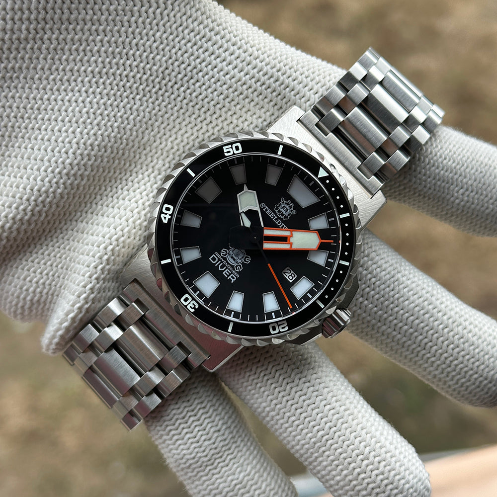 STEELDIVE SD1982F black dial and steel bracelet held in a gloved hand
