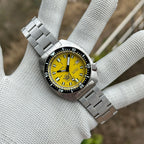 STEELDIVE SD1977T yellow dial Slim Turtle held in a gloved hand on its steel bracelet