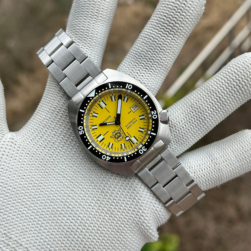 STEELDIVE SD1977T yellow dial Slim Turtle held in a gloved hand on its steel bracelet