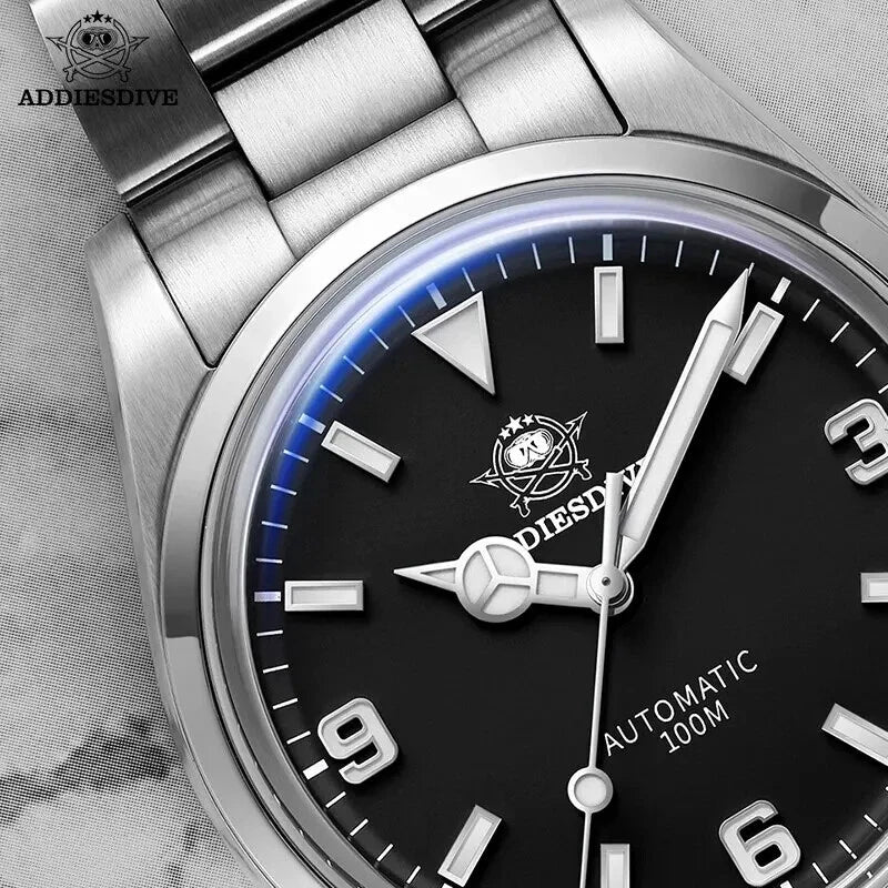 ADDIESDIVE AD2112 automatic Explorer-style macro close-up of black dial showing Mercedes hands and cream lume markers