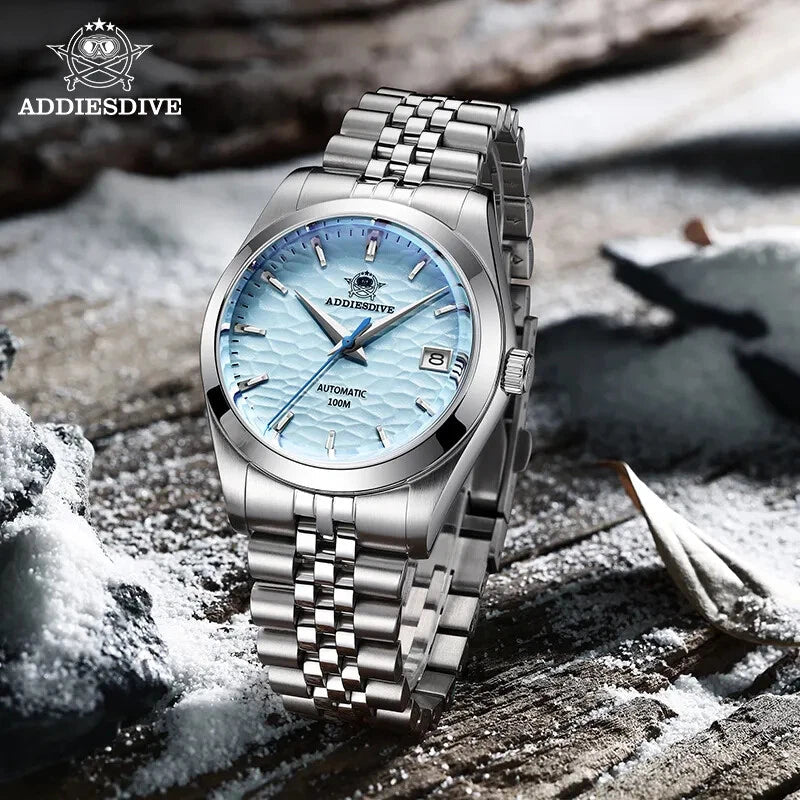 ADDIESDIVE AD2118 automatic dress watch with ice blue hammered dial and jubilee bracelet, lifestyle shot on snowy wood