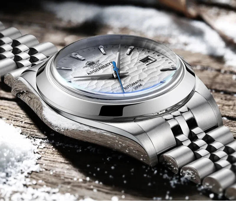 ADDIESDIVE AD2118 automatic dress watch with white hammered dial and jubilee bracelet, small lifestyle shot on snowy wood