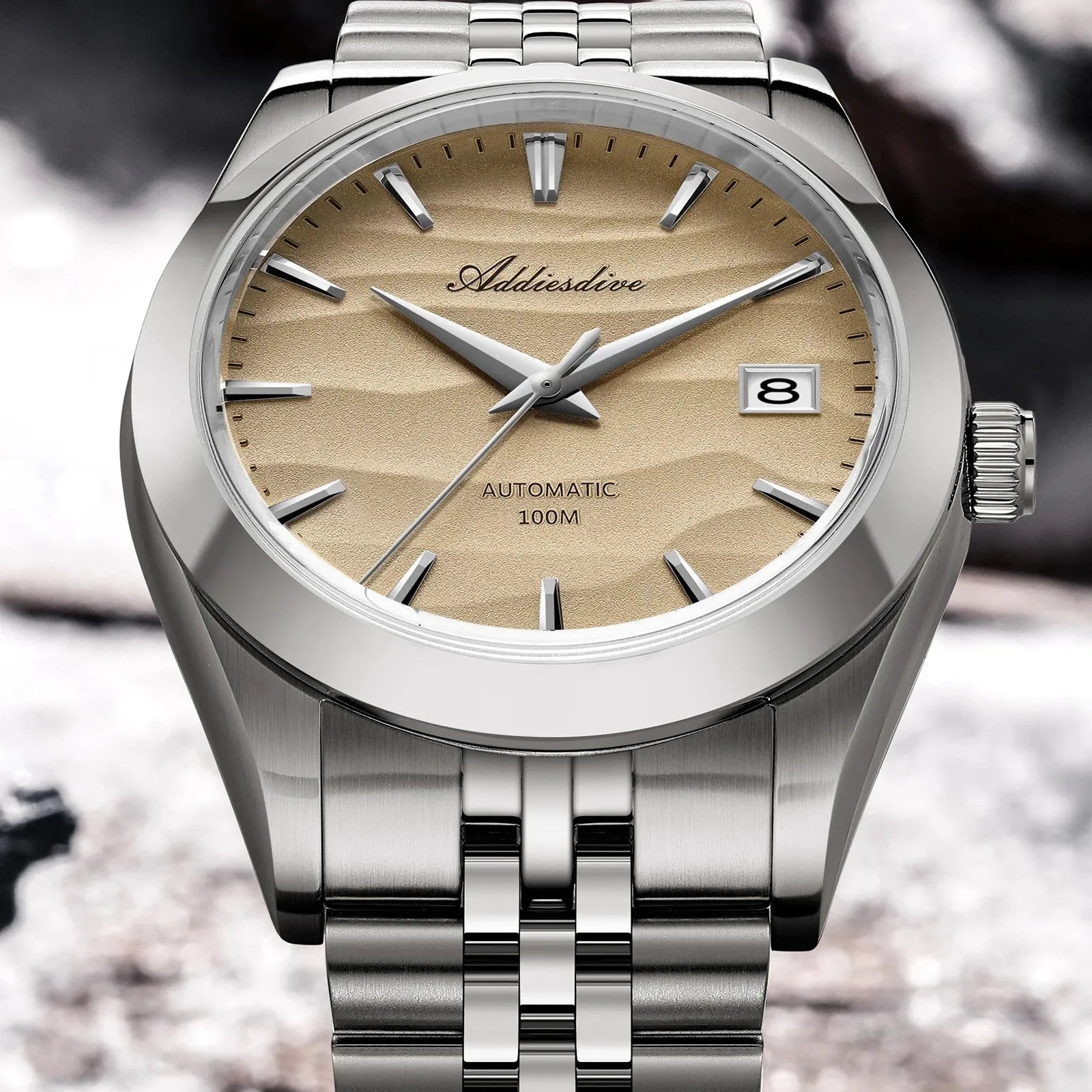 ADDIESDIVE 39MM automatic watch angled view showing sand dial, silver case, signed crown and steel bracelet on rocks