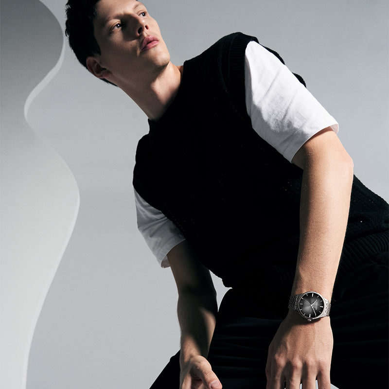 Male model wearing Agelocer Budapest big-date automatic watch with black dial and steel bracelet, lifestyle shot