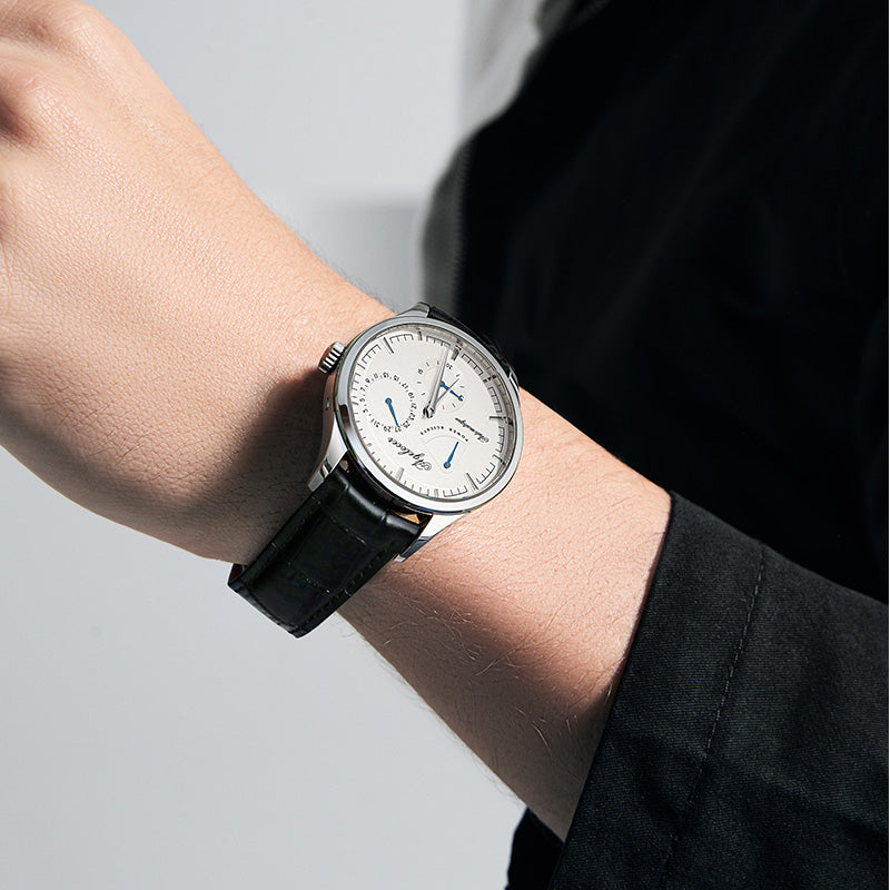 Agelocer Budapest automatic watch with white dial and power reserve display worn on the wrist, close-up view