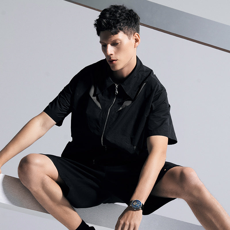 Male model wearing Agelocer free-sprung flying tourbillon watch, seated studio lifestyle shot