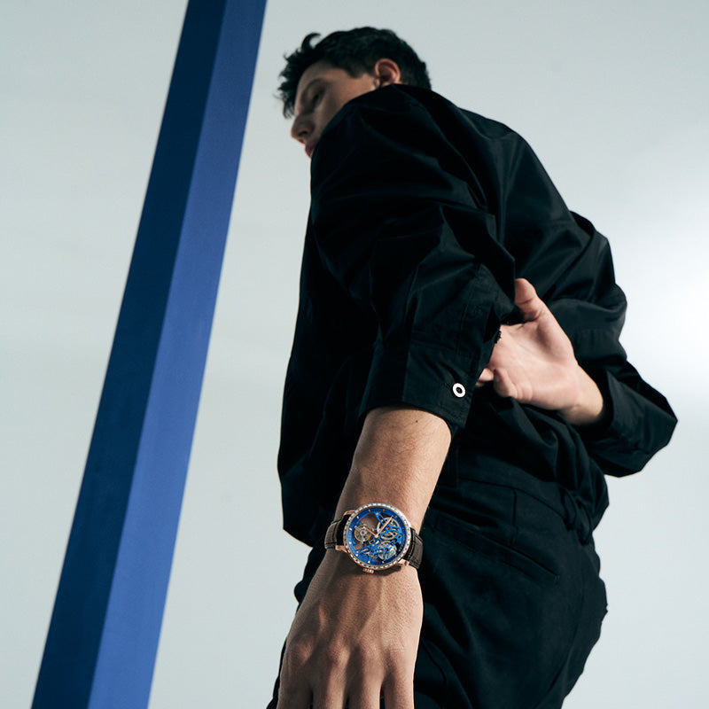 Man walking wearing Agelocer free-sprung diamond tourbillon watch, rose gold case, brown leather strap, lifestyle