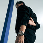 Man walking wearing Agelocer free-sprung diamond tourbillon watch on black leather strap, lifestyle shot