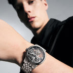 Man wearing Agelocer flying tourbillon skeleton watch on a steel bracelet, wrist view