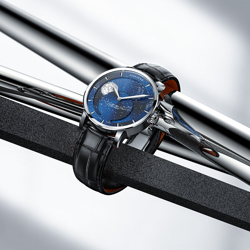 Agelocer Astronomer galaxy moonphase watch with blue starry dial resting on polished steel bars, lifestyle