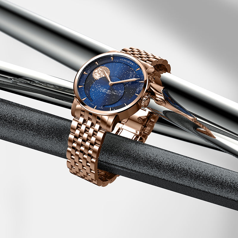 Agelocer galaxy rose gold moon phase watch displayed on polished metal bars, product shot