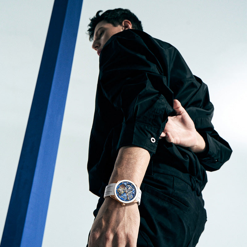 Male model wearing Agelocer hollow tourbillon watch with white rubber strap, dynamic studio lifestyle shot