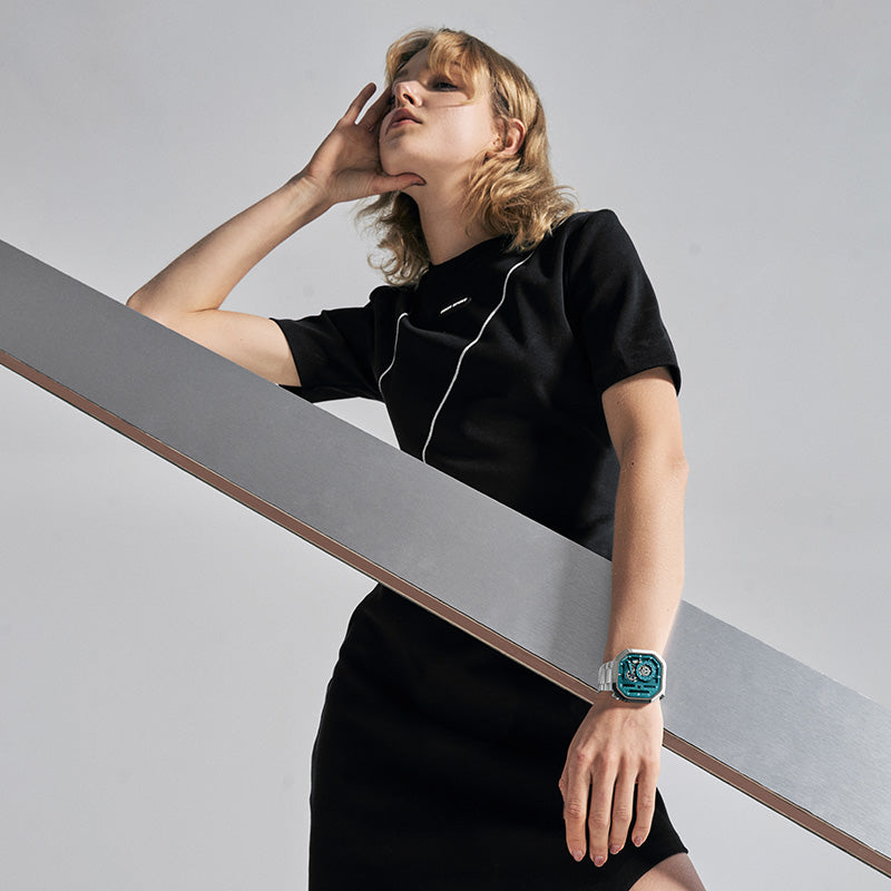 Woman wearing Agelocer Racing Fast & Furious teal skeleton watch on steel bracelet, studio lifestyle shot