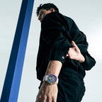 Male model wearing Agelocer rainbow bezel tourbillon skeleton watch with white strap, studio lifestyle shot