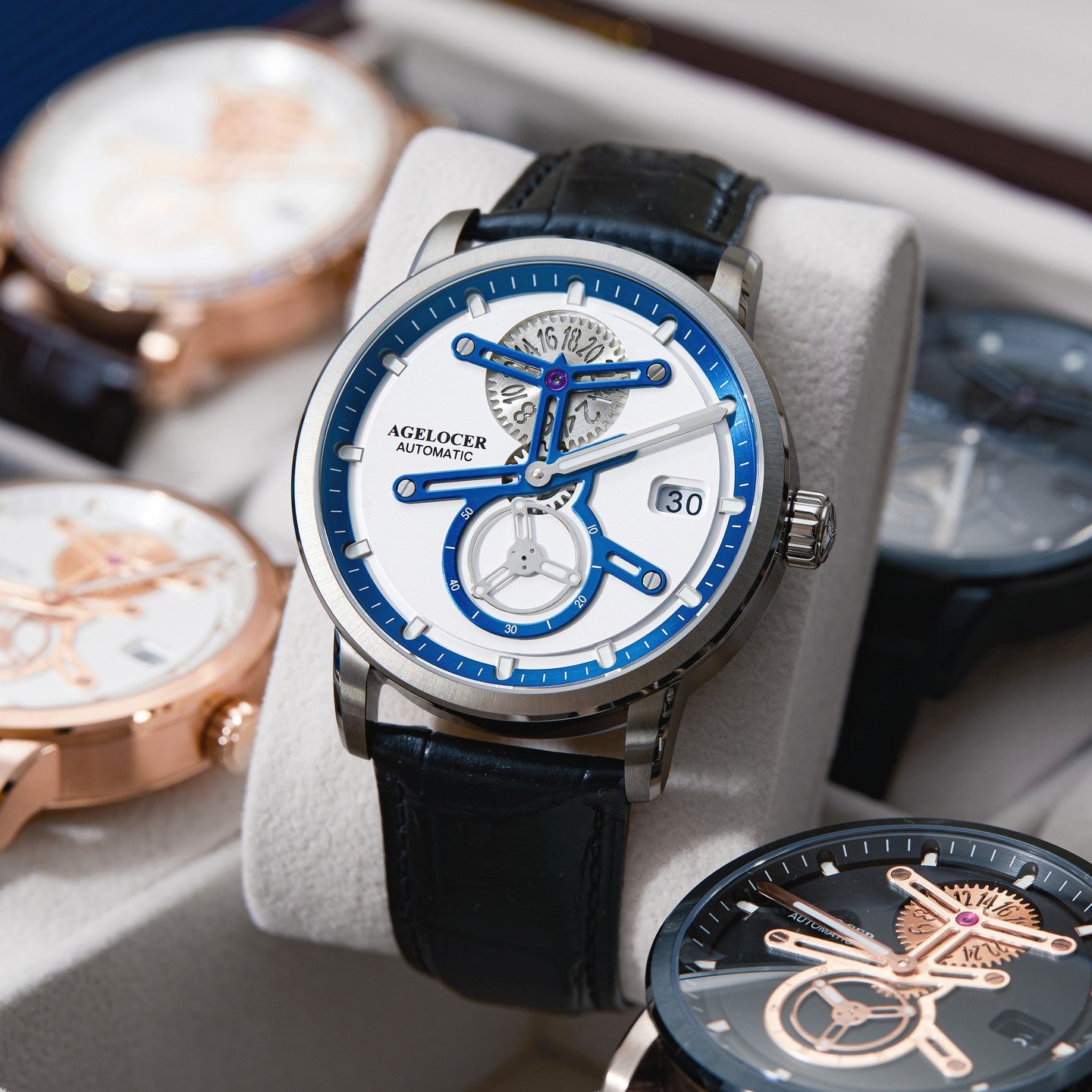 Agelocer Space Station automatic watch with blue dial displayed on a cushion among other Agelocer watches, lifestyle