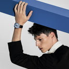 Male model wearing Agelocer Space Station automatic watch with blue dial, dynamic studio lifestyle shot