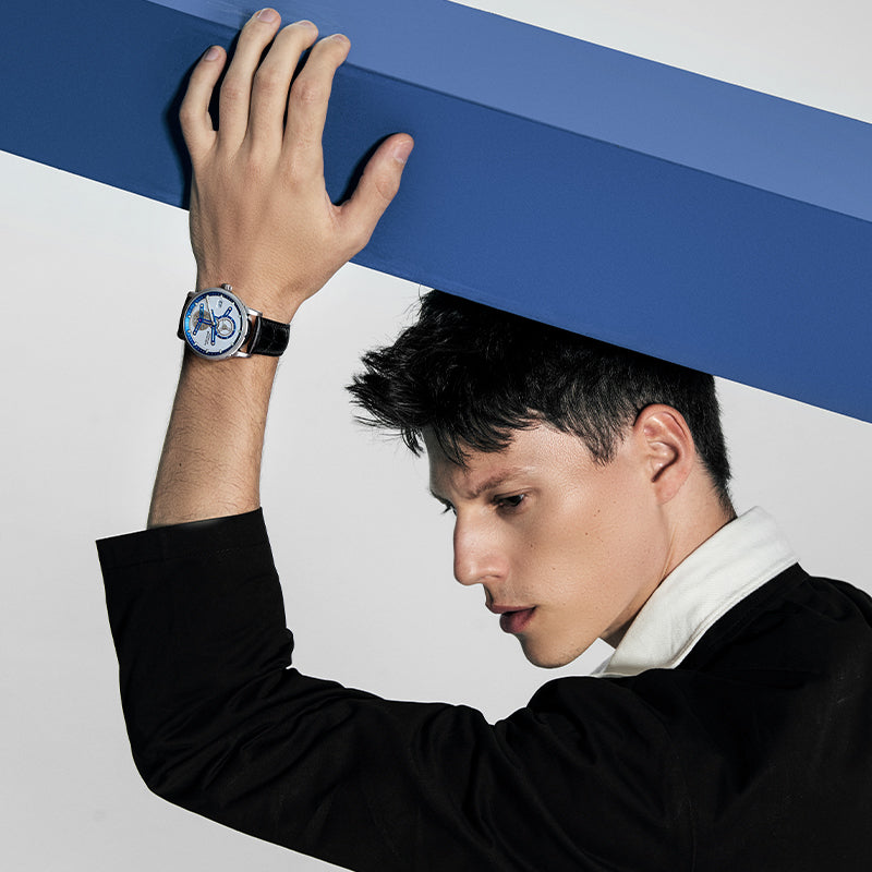 Male model wearing Agelocer Space Station automatic watch with blue dial, dynamic studio lifestyle shot