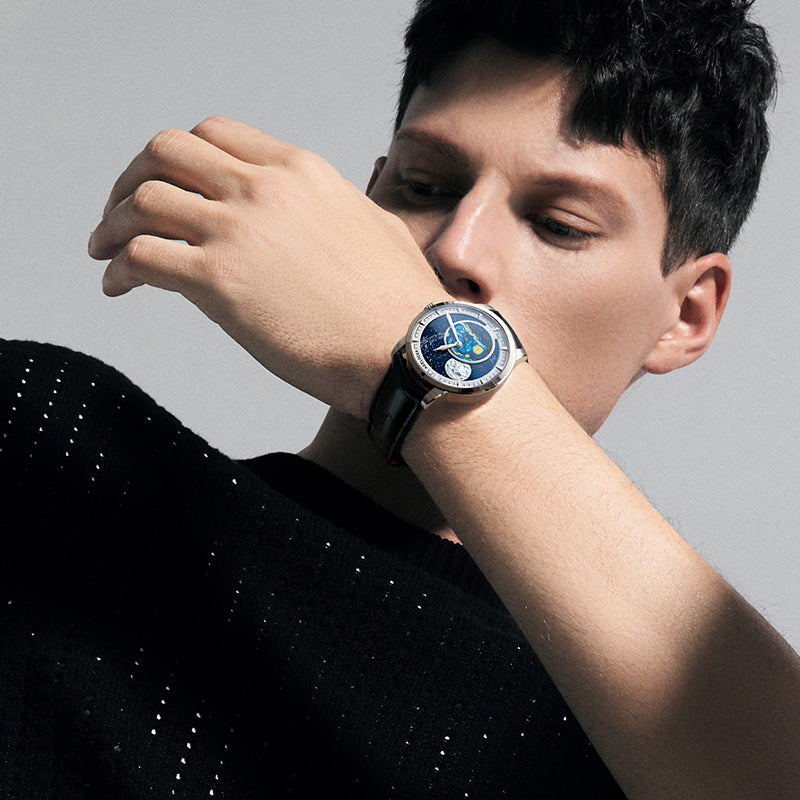 Male model looking at the Agelocer Astronomer painted Starry Night moonphase watch, studio lifestyle shot