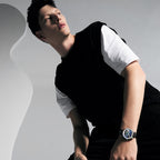 Male model wearing the Agelocer Astronomer painted Starry Night moonphase watch, seated lifestyle shot