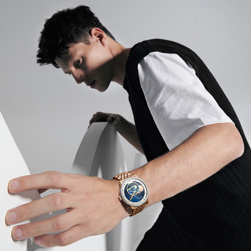 Male model wearing Agelocer Astronomer painted moonphase watch on a rose gold bracelet, wrist lifestyle shot