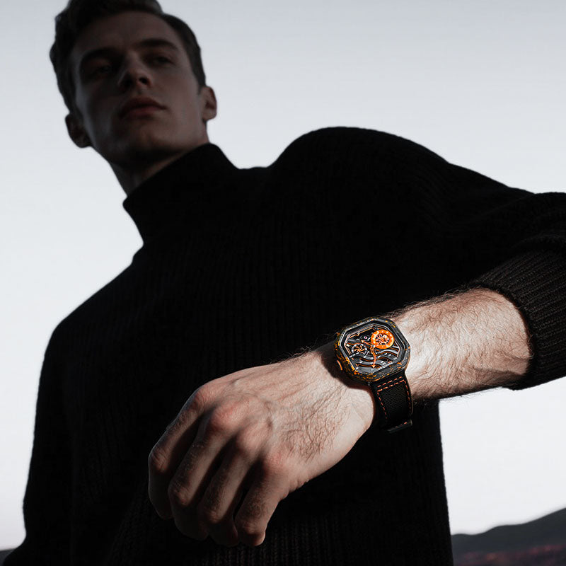 Man wearing Agelocer Volcano orange carbon fibre skeleton watch on black rubber strap, lifestyle portrait