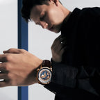 Male model wearing Agelocer World Time watch with blue globe dial and rose gold case, lifestyle shot