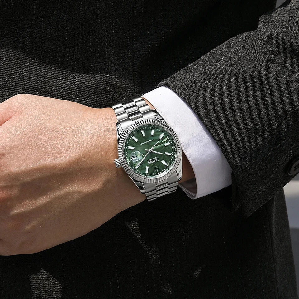 CADISEN C8198M watch wrist shot showing olive green palm motif dial and stainless steel bracelet worn with suit