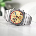 Ciloa retro chronograph with cream dial resting on open book with plant in background