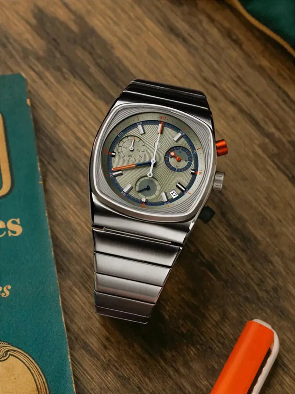 Ciloa retro chronograph watch on wood beside teal vintage book and orange pen
