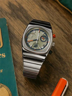 Ciloa retro chronograph watch on wood beside teal vintage book and orange pen