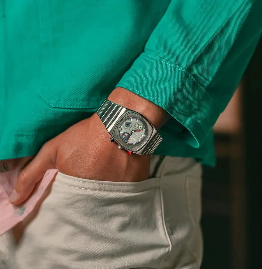 Ciloa retro chronograph watch on wrist of model with hand in pocket wearing green shirt