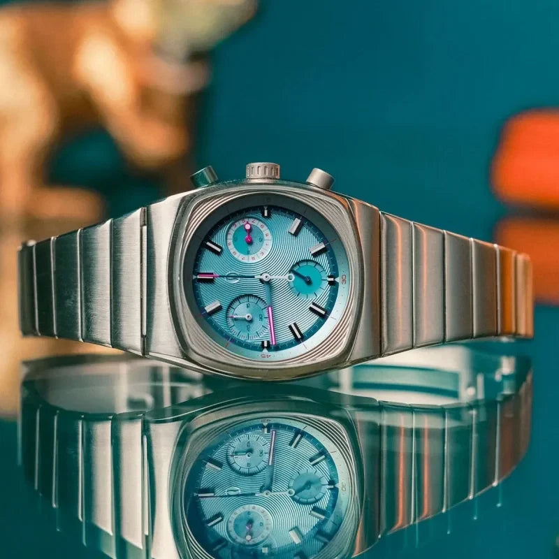 Ciloa retro chronograph with ice blue dial reflected on glossy surface with teal background