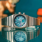Ciloa retro chronograph with ice blue dial reflected on glossy surface with teal background