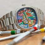 Ciloa painted dial watch with graffiti blue dial on wood surface beside watchmaker tools