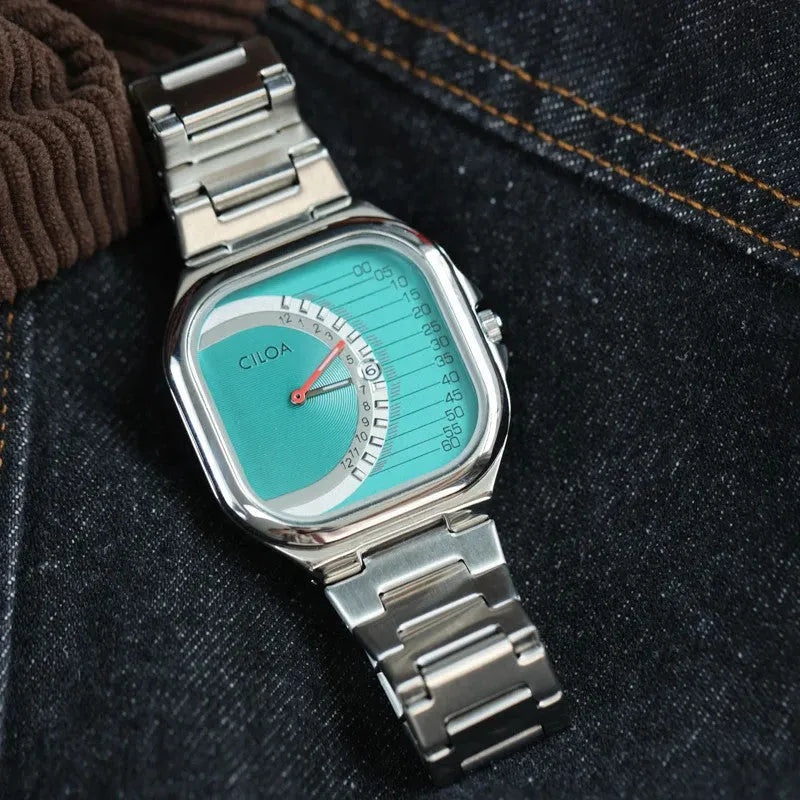 CILOA retro square quartz watch with teal dial laid on denim and corduroy fabric