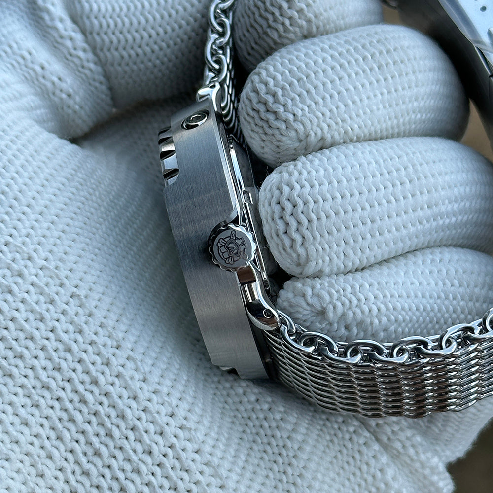 Crown-side profile of the STEELDIVE SD1975N steel shroud on a steel mesh bracelet