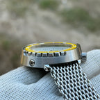 Low side view of the STEELDIVE SD1975N steel shroud with yellow bezel on a mesh bracelet