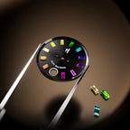 Lucky Harvey ZLS305-2 watch black dial held by tweezers with loose colored gemstone markers