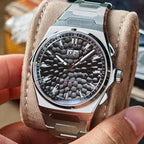 Lucky Harvey ZLS402-2 black hammer chiming watch held in hand on suede pillow lifestyle scene