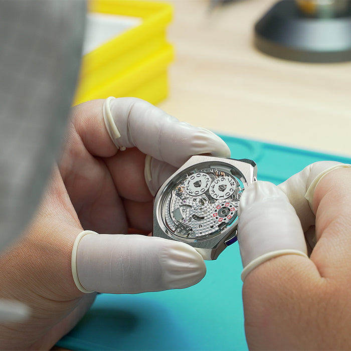 Lucky Harvey ZLS402-3 watchmaker holding cased chiming movement in cleanroom