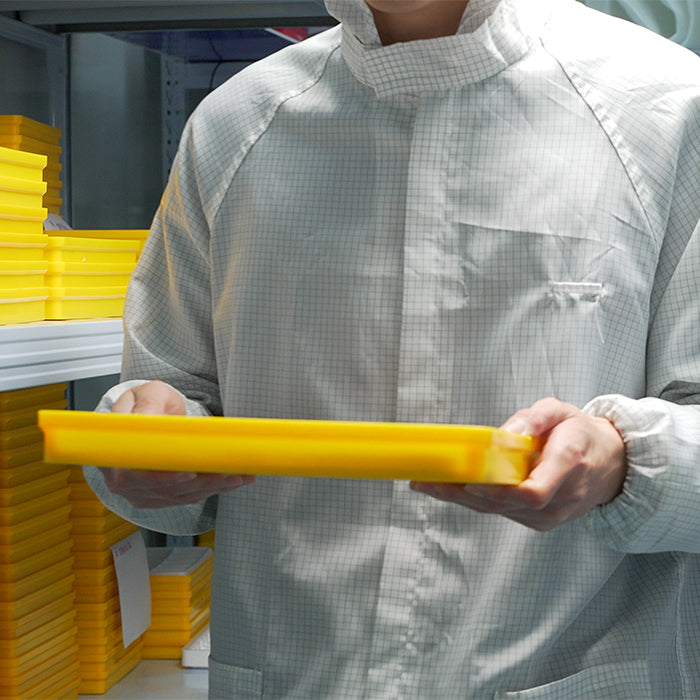 Lucky Harvey ZLS402-4 factory technician carrying yellow component tray in cleanroom