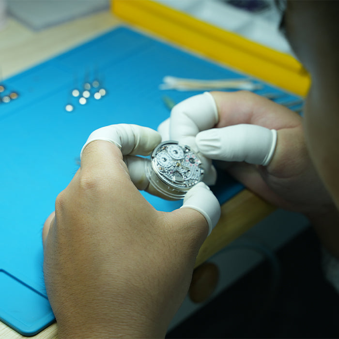 Lucky Harvey ZLS402-4 watchmaker inspecting LH003 chiming movement at workbench