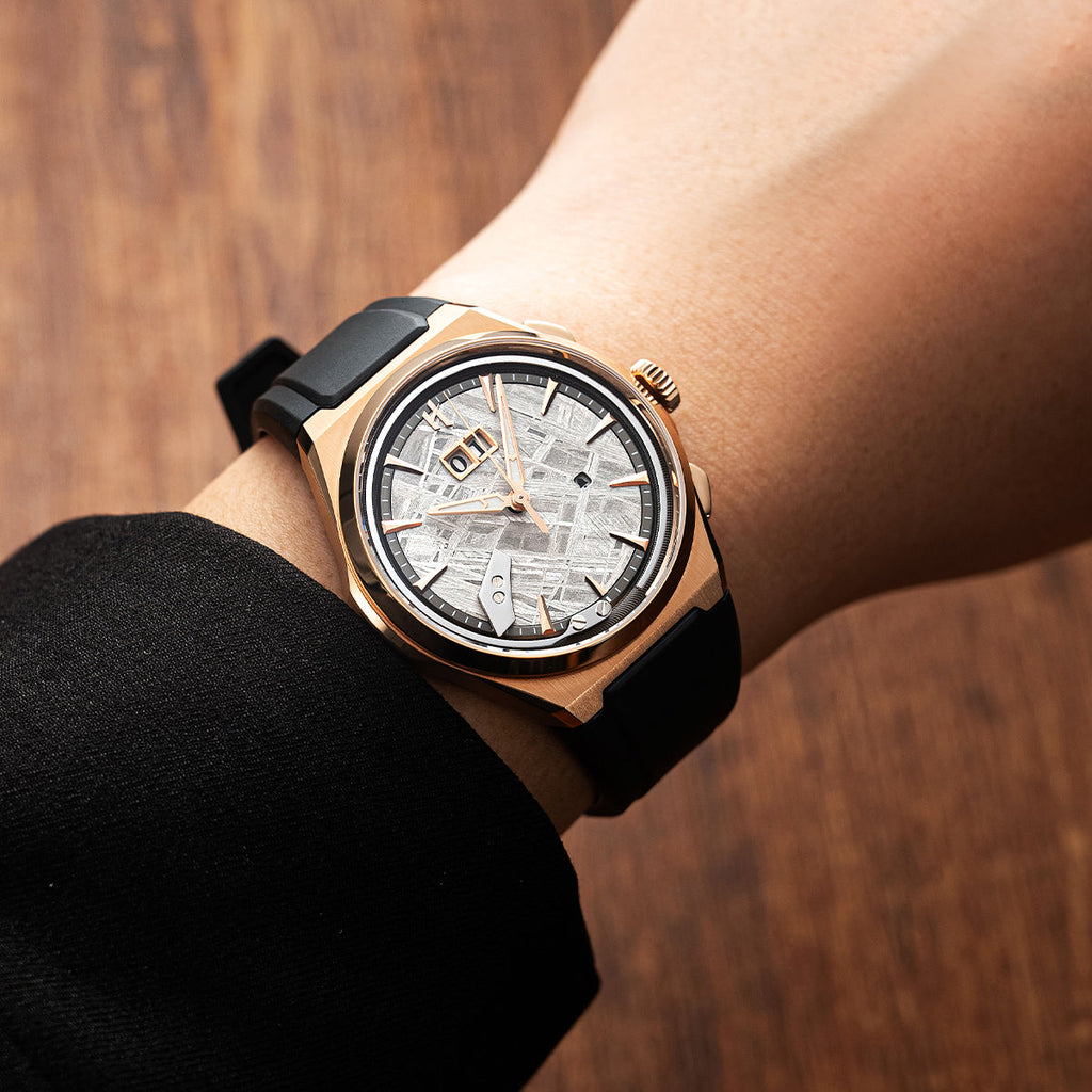 Lucky Harvey ZLS413-1 rose gold meteorite watch on wrist with black rubber strap over wood