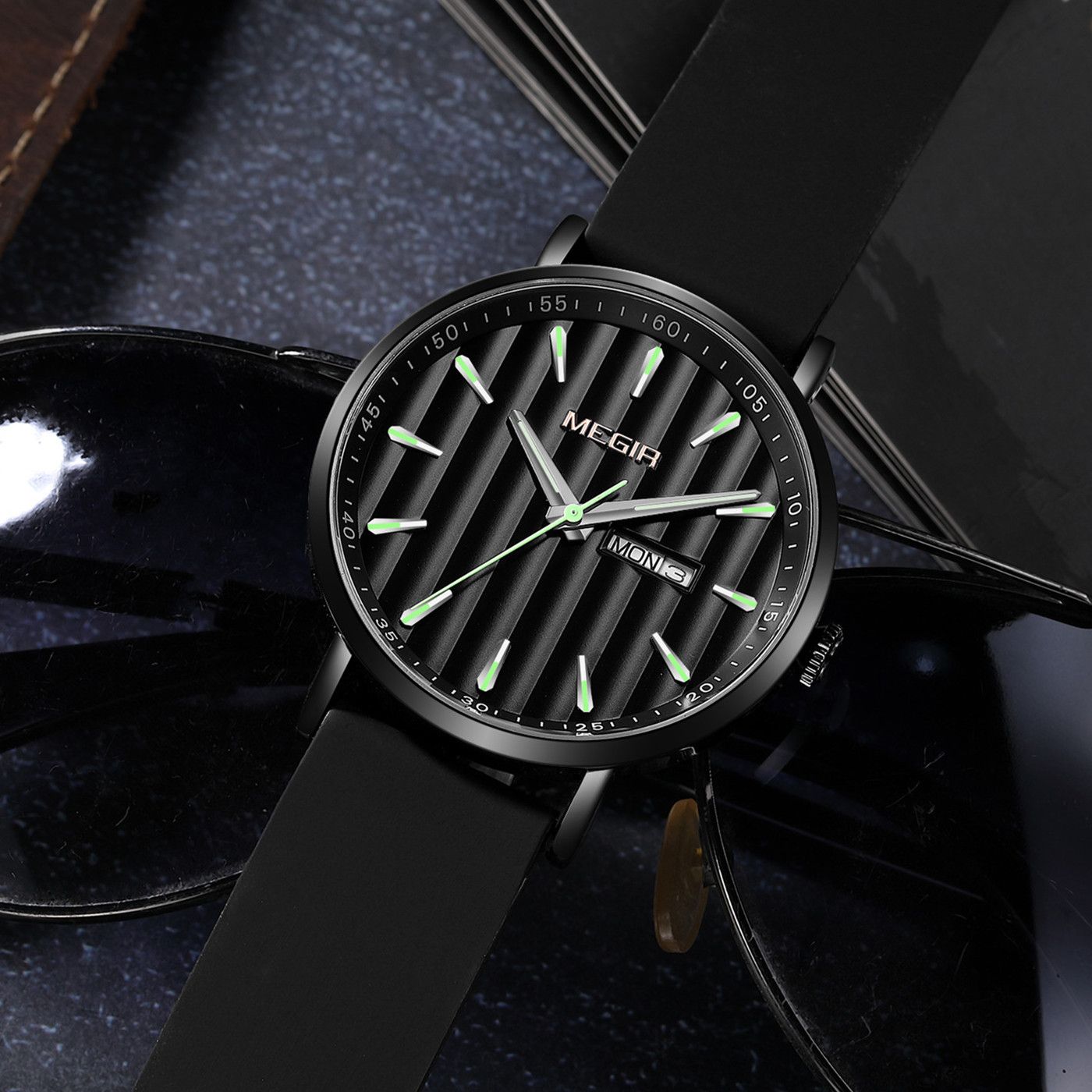 MEGIR 1081 men's watch, black fluted dial and black case on a black strap, resting beside sunglasses